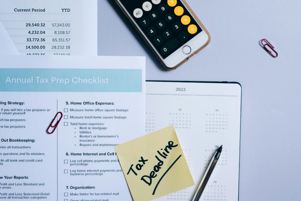 Organized tax preparation setup featuring checklist, calendar, and smartphone calculator for effective planning.